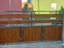 Portal de acero inoxidable con lamas de aluminio lacado.